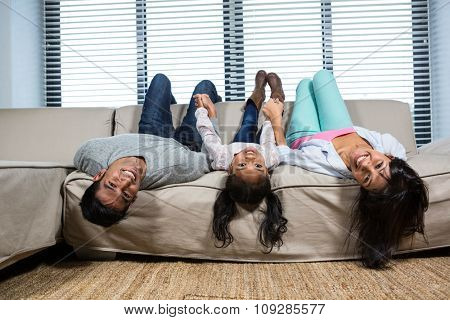 Happy family hanging upside down in living room