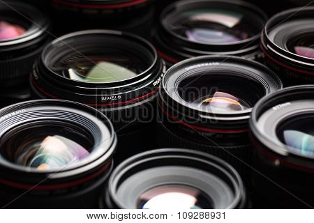 Modern camera lenses with reflections, low key image