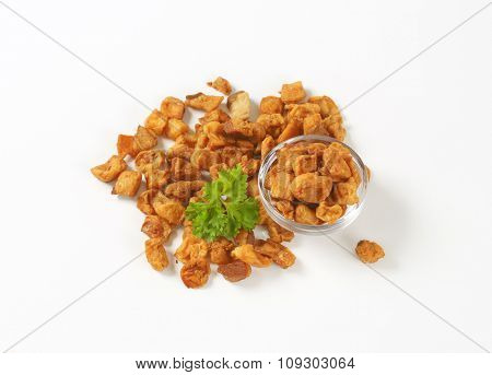bowl of salty pork greaves on white background