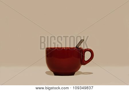 Large glossy red round cup with a handle and a spoon