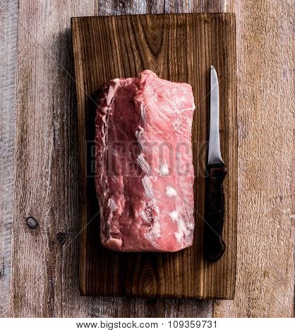 big piece of raw meat on cutting board