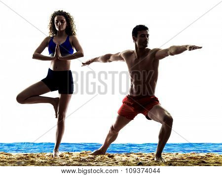 one caucasian couple man and woman yoga exercices on the beach silhouette isolated on white background