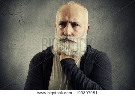 portrait of despondent senior man over grey background
