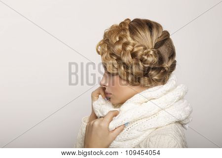 portrait of a beautiful young blonde woman on a light background. hair tied in a braid. girl wearing