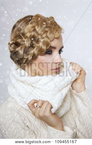 portrait of a beautiful young blonde woman on a light background. hair tied in a braid. girl wearing
