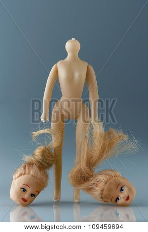 beheaded doll holding heads