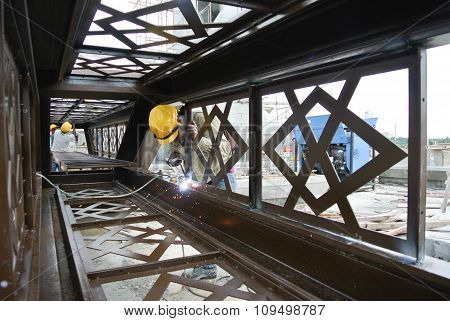 Welders welded the decorative mild steel at the construction site
