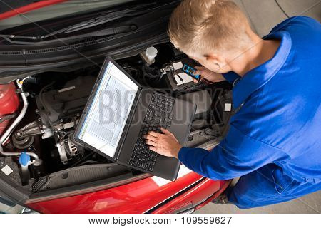 Mechanic Using Laptop To Repair Car