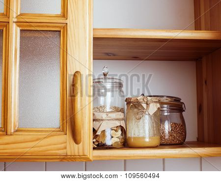 real comfort wooden kitchen with breakfast ingredients close up in glass, honey, oatmeal, milk, mues