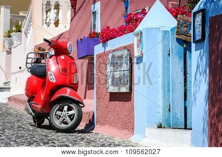 ed motor scooter as a part of decoration at color street of Thira town
