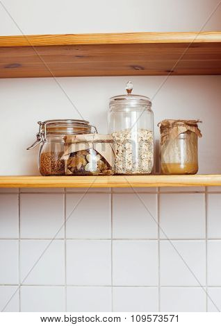real comfort wooden kitchen with breakfast ingredients close up in glass, honey, oatmeal, milk, mues