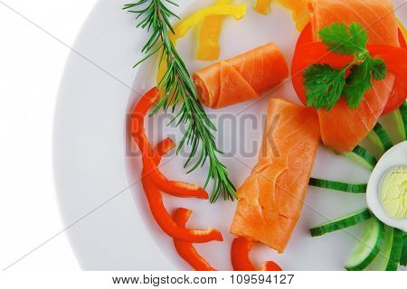smoked salmon slices with vegetabls over white plate