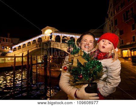 Happy Mother And Daughter With Christmas Tree In Venice, Italy.