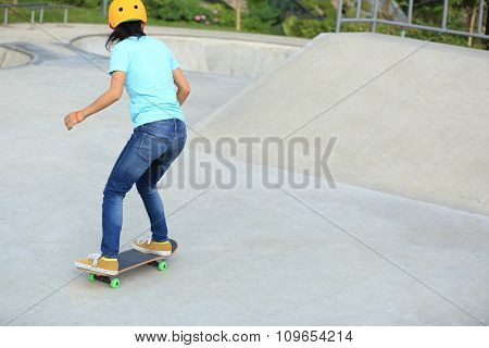 young woman skateboarder skateboarding at skatepark