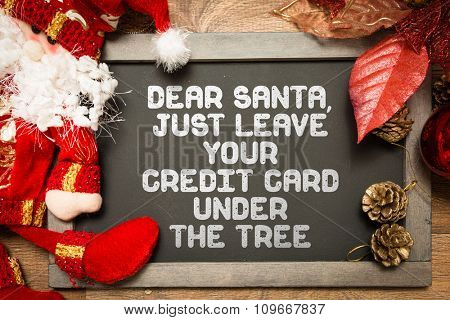 Blackboard with the text: Dear Santa, Just Leave Your Credit Card Under the Tree