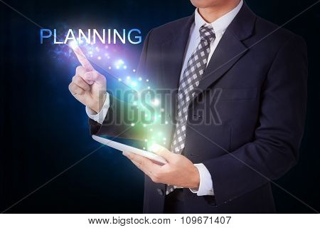 Businessman holding tablet with pressing planning.