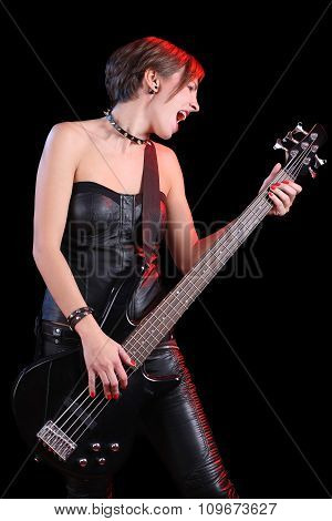 Sexy girl in leather clothes with bass guitar. punk rocker