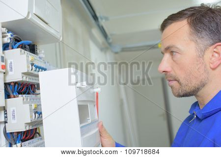 electrician looking at fusebox