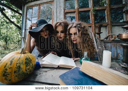 Three vintage witches perform magic ritual