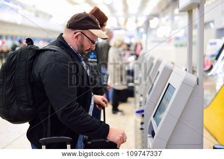 GENEVA, SWITZERLAND - NOVEMBER 19, 2015: passenger use self-registration kiosk in Geneva Airport. Geneva International Airport is the international airport of Geneva, Switzerland.
