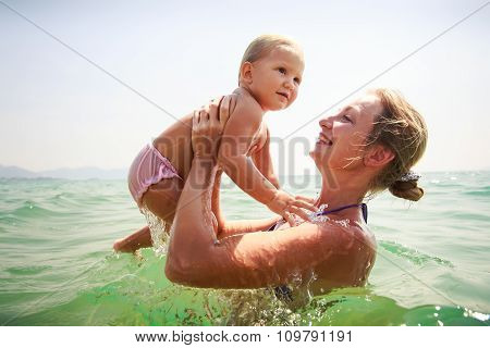 Mother Small Daughter Bathe In Transparent Azure Sea Smile