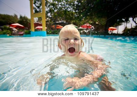 Small Blonde Girl Swims Cries With Joy In Water Of Pool