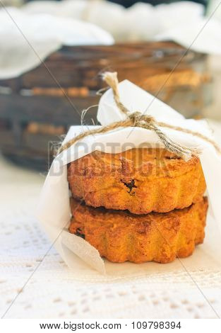 Homemade rustic muffins with pumpkin and oatmeal on bowl with white greaseproof paper.