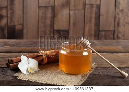 Heather honey and cinnamon on wooden table.