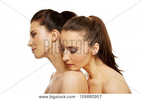 Two attractive topless sisters with make up.