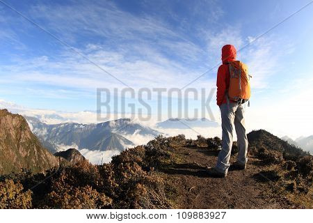 young woman hiker hiking on mountain peak