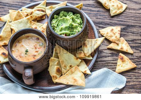 Bowls Of Guacamole And Queso With Tortilla Chips