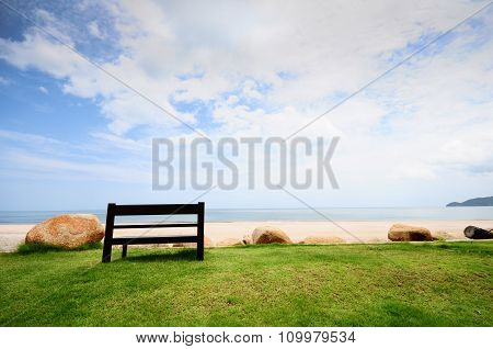 A Wooden Bench Near A White Sand Beach Looking To The Ocean