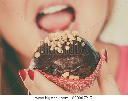 Woman Holding Chocolate Cupcake About To Bite