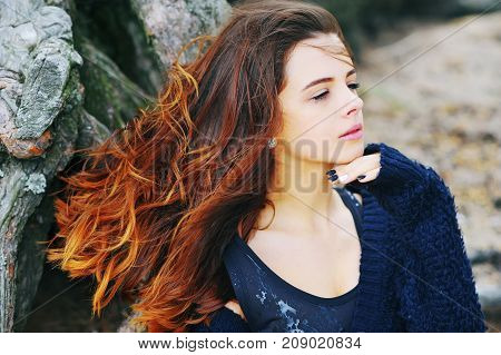 Portrait of young beautiful sad and desperate woman suffering from depression, sad looks away with tears in his eyes in a Park near a tree.