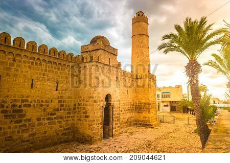 The walls and towers of the fortress of Ribat of Sousse in Tunisia. Medieval architecture in sunset light.