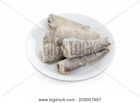 Several carcasses of the frozen saltwater fish notothenia without of a heads and tails on a white dish on a white background