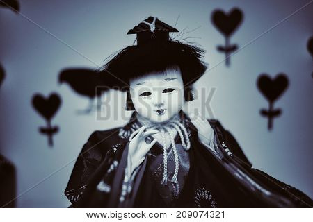 Japanese doll face fear in dark Background.