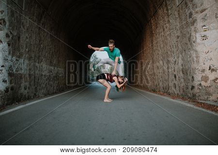 Couple playing leapfrog jumping in a tunnel