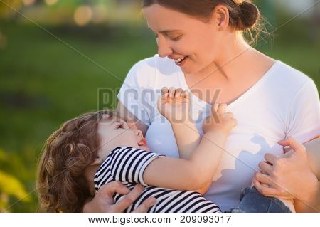 Adorable little daughter with her mother. Loving daughter. Attractive youang mother. Time with parents. Caring mother happy family. Summer sunny days beautiful lightings.