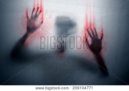 Angry ghost with bloody hands covered by sheet