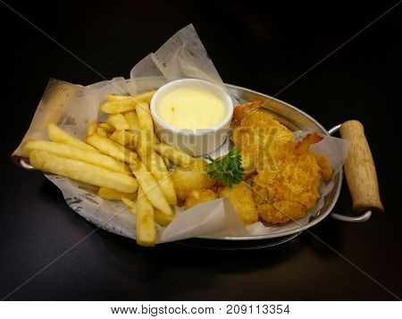 French fries and Nuggets with mayonnaise sauce are fast foods On a black table