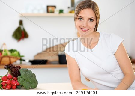 Young woman is making online shopping by tablet computer and credit card. Housewife found new recipe for cooking in a kitchen.
