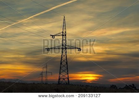 electricity pillars at sunset silhouettes on beautiful orange sky