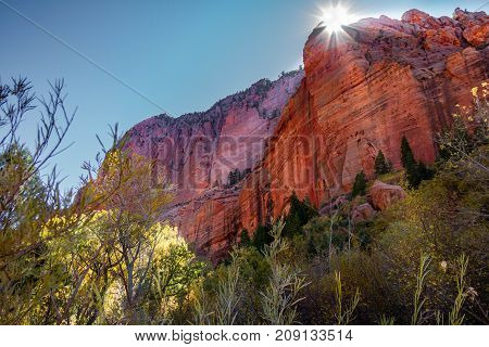 Gorgeous view of Kolob Canyon part of Zion National Park in Utah with a Sunburst illuminating the rock and sky.