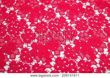 bright crimson, red guipure smoothly laid out on a white table