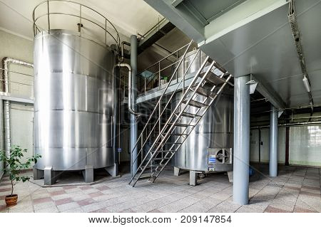 Two metal tanks installed inside the building. Equipment for mixing sugar and yeast mixture.