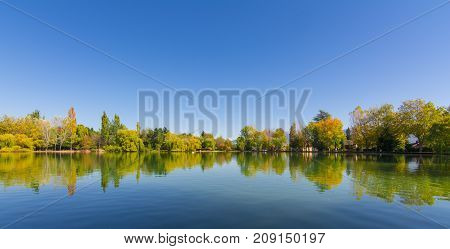 Autumn colors and reflection on Puigcerda's pond in Pyrenees. Located in north Catalonia, Spain.