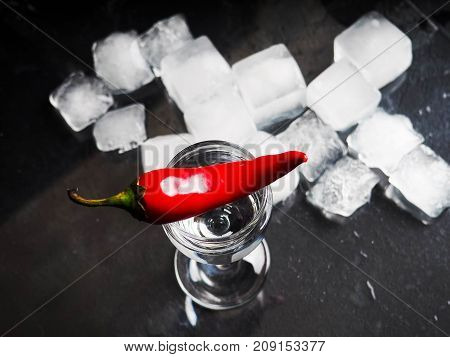 A Shot Of Vodka, An Alcoholic Beverage, Next To Ice, Fire, Ice, Red Chili Pepper. The Concept Of Alc