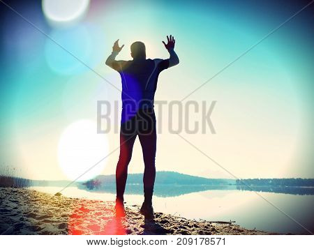 Jumping Man. Sportsman Crazy Jumping  And Jogging On Beach During The Sunrise