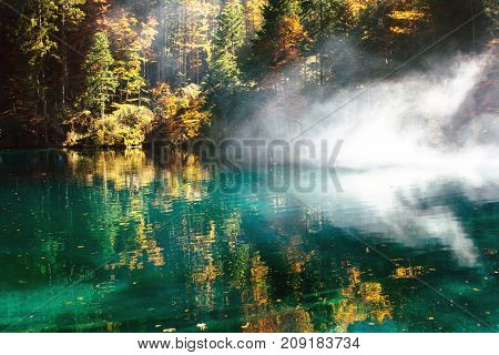 Autumn time at romantic forest lake blausee, one of the best known mountain lakes in Switzerland.
